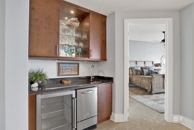 bar with light tile patterned floors, a sink, wet bar, beverage cooler, and fridge