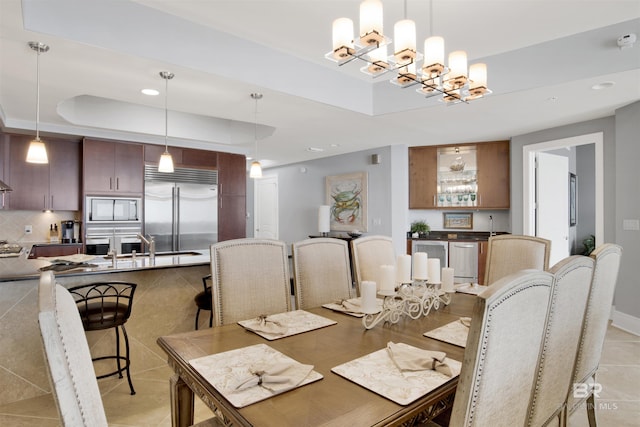 dining room featuring light tile patterned floors, baseboards, an inviting chandelier, a tray ceiling, and recessed lighting