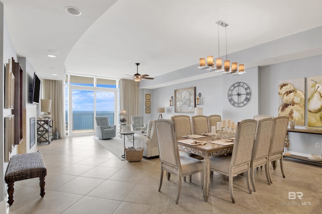 dining room with light tile patterned floors, a wall of windows, and ceiling fan with notable chandelier