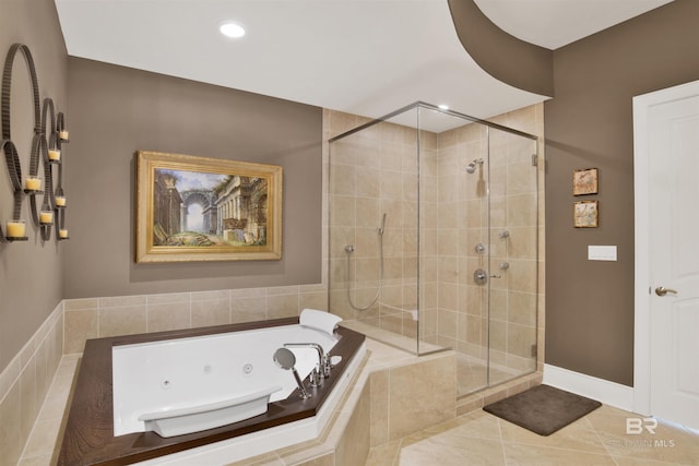 bathroom with tile patterned flooring, a jetted tub, a shower stall, and baseboards