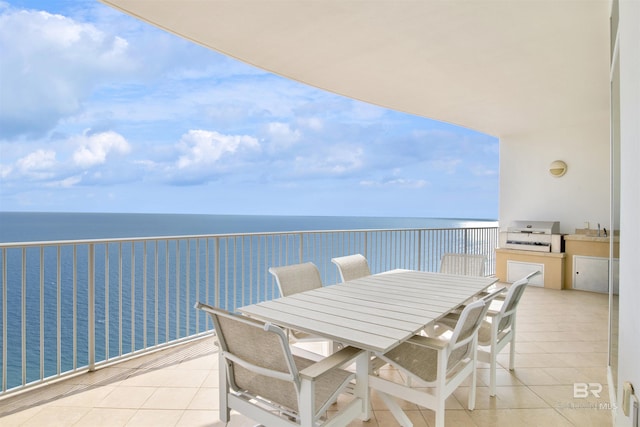 balcony featuring an outdoor kitchen, outdoor dining area, a water view, and a grill