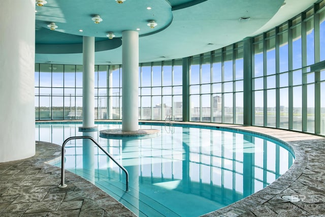 pool featuring glass enclosure and a patio