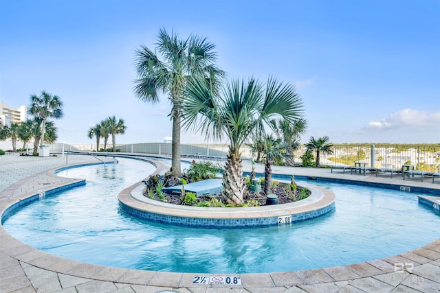 community pool with a patio area and fence