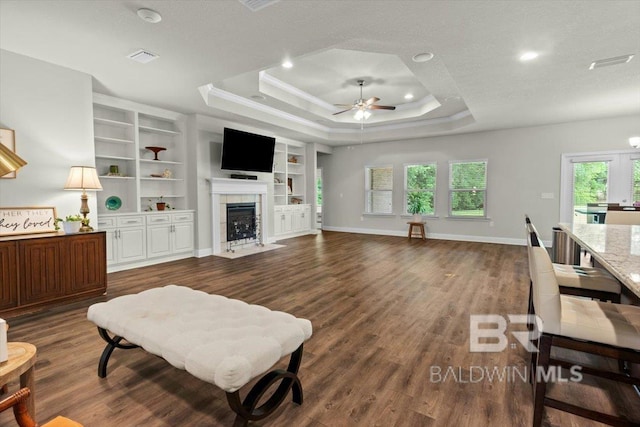 living room with ceiling fan, a raised ceiling, dark wood-style floors, healthy amount of natural light, and recessed lighting