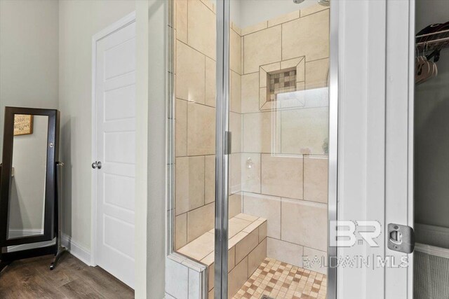 full bath featuring a shower stall and wood finished floors