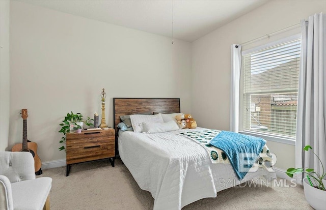 bedroom with light colored carpet and baseboards