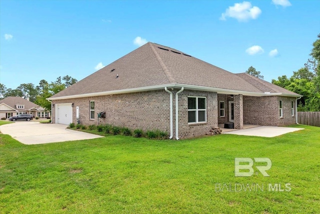 back of property featuring a patio area, an attached garage, brick siding, concrete driveway, and a shingled roof