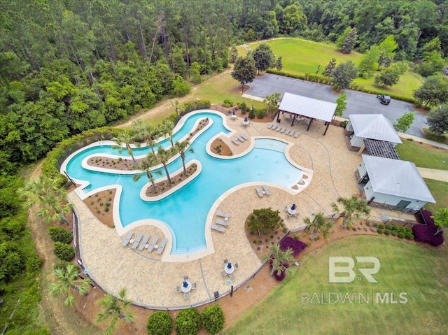 aerial view of a pool and a heavily wooded area