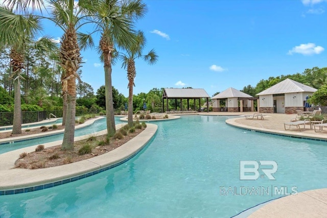 community pool with a gazebo, a patio, and fence
