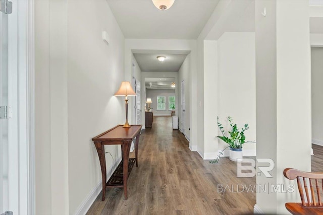 corridor with wood finished floors and baseboards