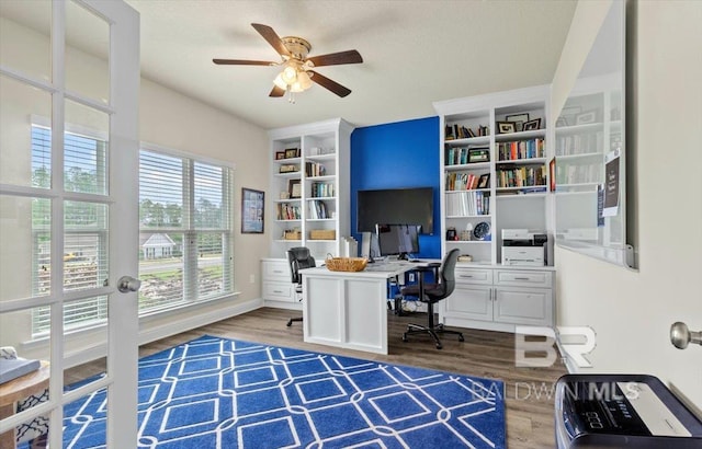 office space featuring wood finished floors, ceiling fan, built in features, and baseboards