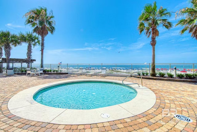 view of swimming pool with a patio area and a water view