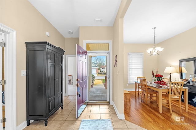 entryway featuring light tile patterned floors and a notable chandelier