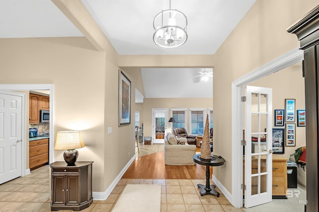 corridor featuring light tile patterned flooring and an inviting chandelier