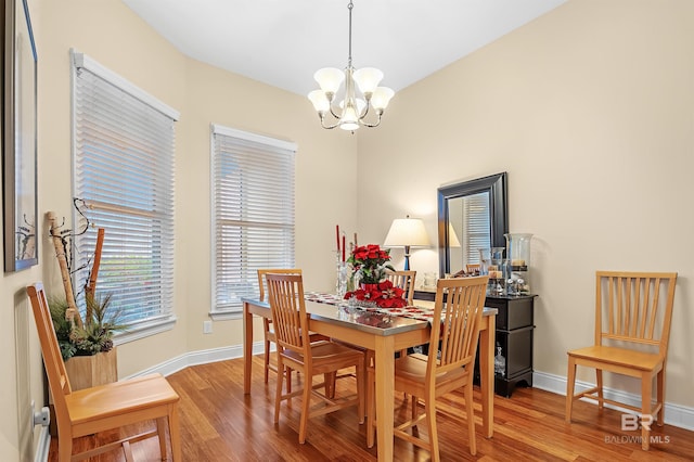 dining area featuring hardwood / wood-style floors and a notable chandelier