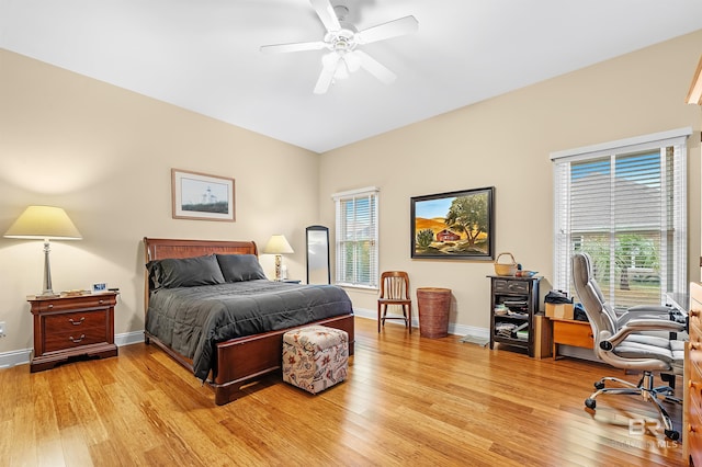 bedroom featuring multiple windows, ceiling fan, and light wood-type flooring