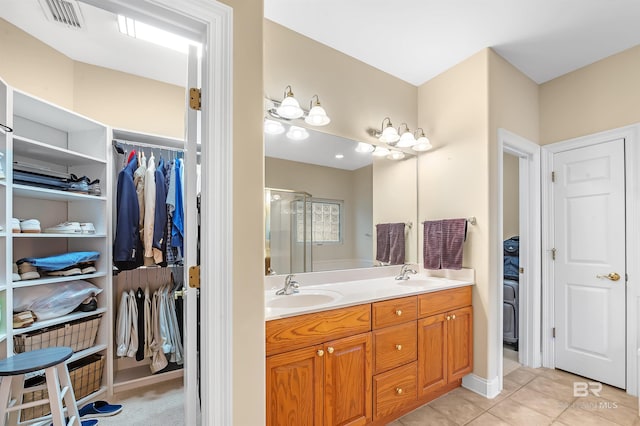 bathroom featuring tile patterned flooring, vanity, and an enclosed shower