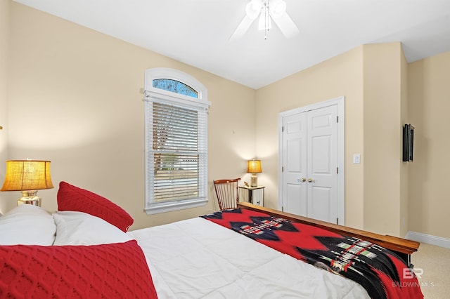 carpeted bedroom with ceiling fan and a closet