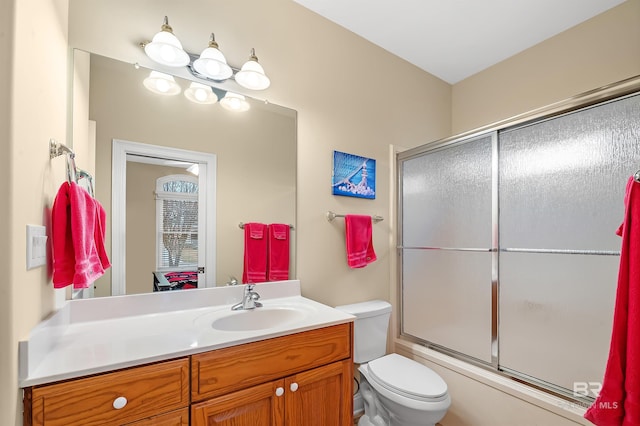 full bathroom with vanity, toilet, and bath / shower combo with glass door