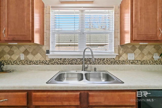 kitchen with backsplash, sink, and black dishwasher