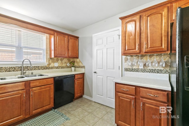 kitchen featuring decorative backsplash, sink, light tile patterned flooring, and black appliances