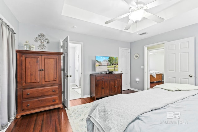 bedroom with hardwood / wood-style floors, ensuite bathroom, and ceiling fan