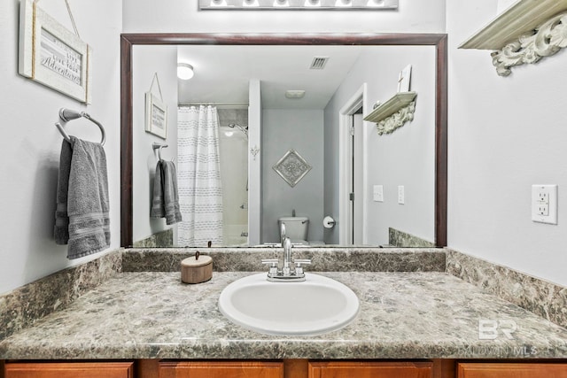 bathroom with a shower with curtain, vanity, and toilet