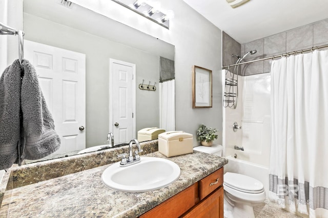 full bathroom featuring vanity, shower / bath combination with curtain, and toilet