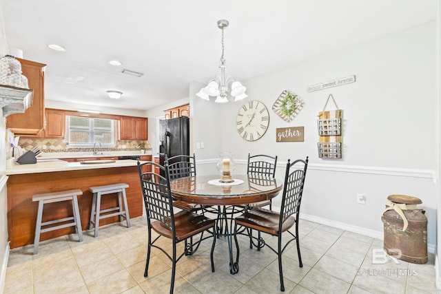 dining area featuring sink, light tile patterned floors, and a notable chandelier