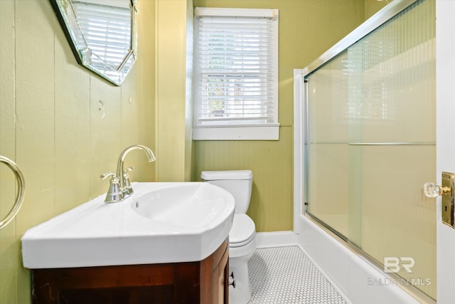 full bathroom with tile patterned floors, sink, bath / shower combo with glass door, and toilet