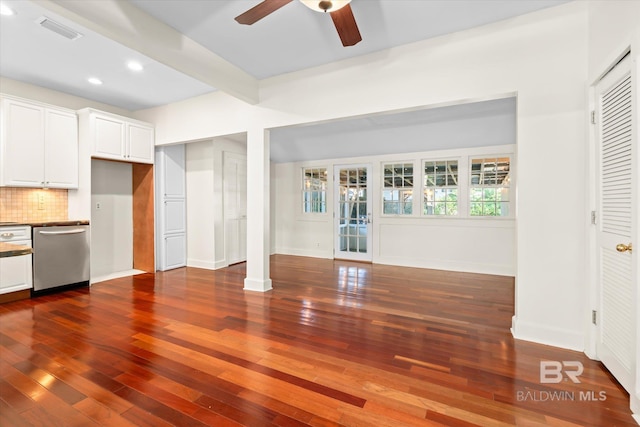 unfurnished living room featuring beamed ceiling, dark hardwood / wood-style floors, and ceiling fan