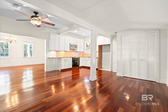 unfurnished living room with ceiling fan with notable chandelier and dark hardwood / wood-style flooring