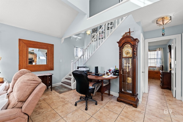 office featuring light tile patterned floors, lofted ceiling, and baseboards