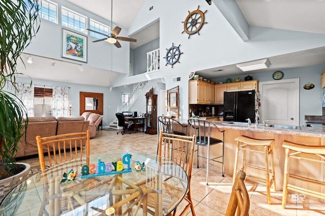 dining room with light tile patterned flooring, visible vents, lofted ceiling, and ceiling fan