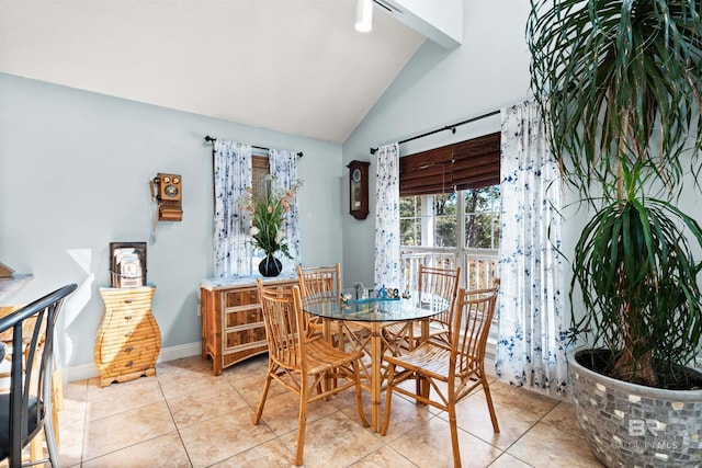 tiled dining area with baseboards and vaulted ceiling