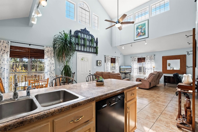 kitchen featuring light tile patterned floors, plenty of natural light, black dishwasher, and a sink