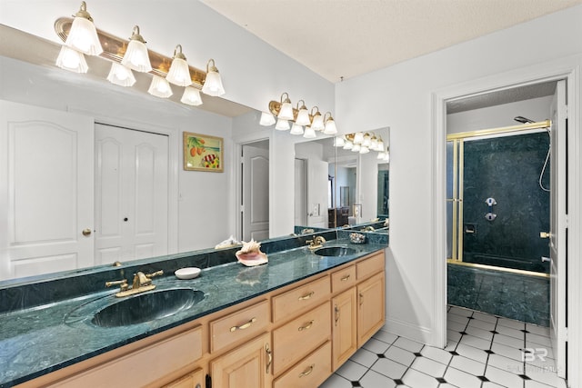 bathroom featuring a textured ceiling, double vanity, baseboards, and a sink