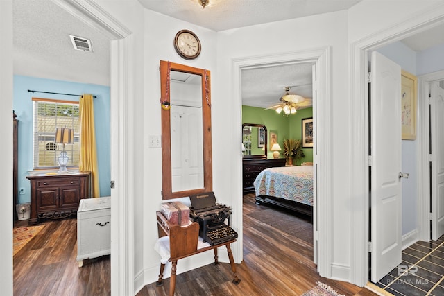 bedroom with visible vents, dark wood-style flooring, and a textured ceiling