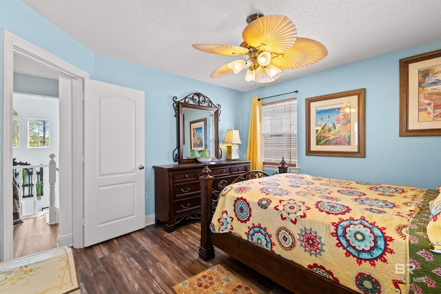 bedroom featuring baseboards, dark wood-type flooring, ceiling fan, and a textured ceiling