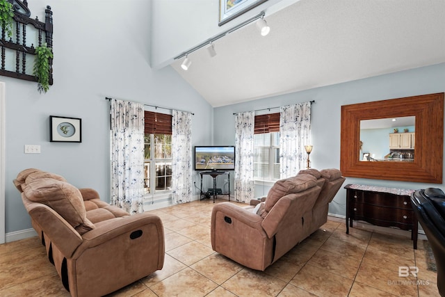 living room featuring beam ceiling, high vaulted ceiling, track lighting, light tile patterned floors, and baseboards