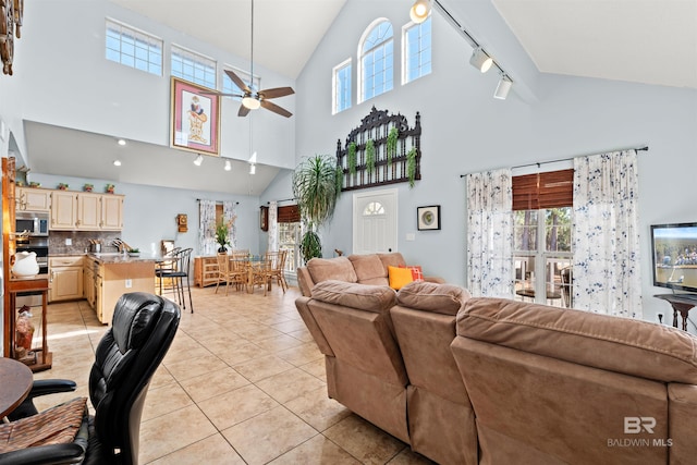 living room with light tile patterned floors, rail lighting, lofted ceiling, and ceiling fan