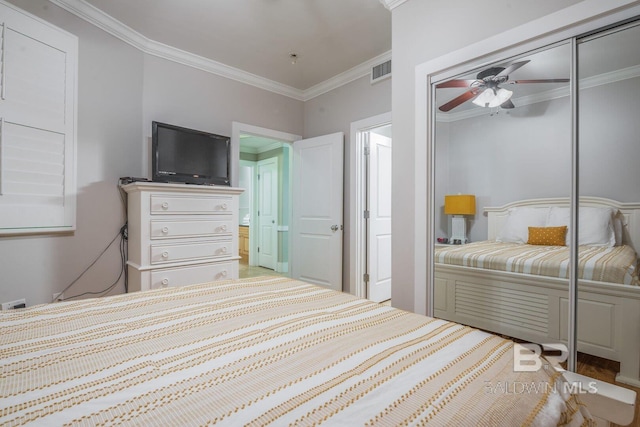 bedroom featuring ceiling fan, ornamental molding, hardwood / wood-style flooring, and a closet