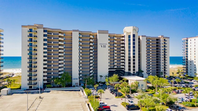 view of building exterior featuring a water view and a view of the beach