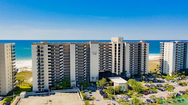 view of building exterior with a water view and a beach view