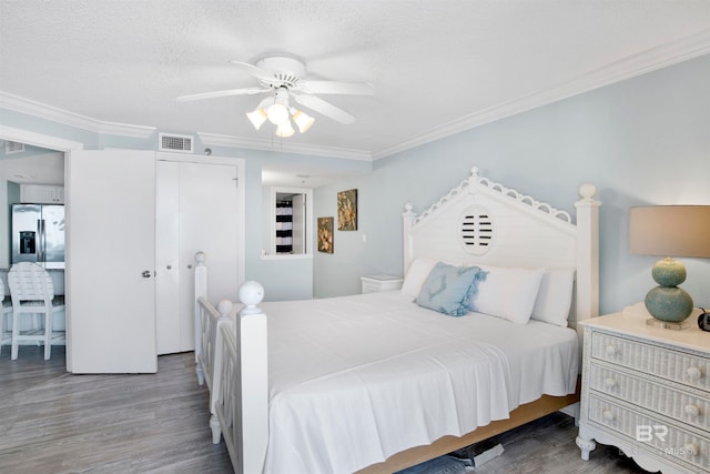 bedroom featuring ornamental molding, a textured ceiling, ceiling fan, hardwood / wood-style flooring, and a closet