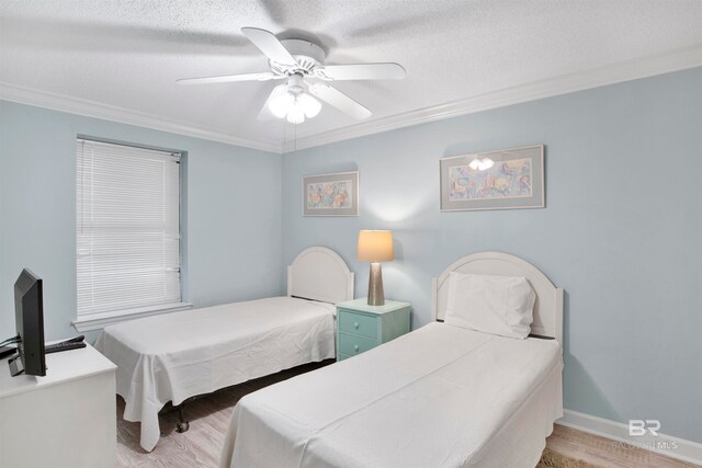 bedroom with ceiling fan, crown molding, light hardwood / wood-style floors, and a textured ceiling