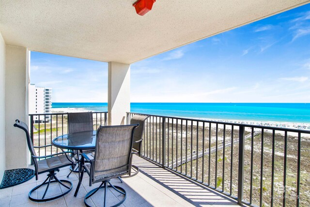 balcony featuring a water view and a beach view