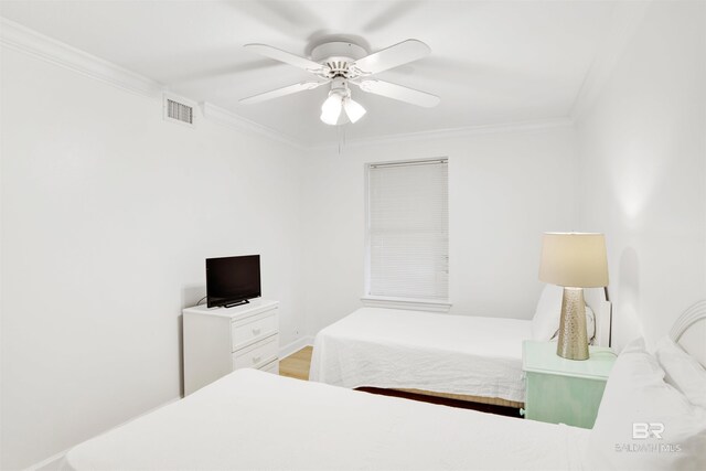 bedroom with ceiling fan and crown molding