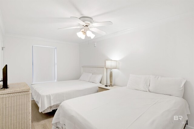 bedroom with light hardwood / wood-style floors, ceiling fan, and crown molding