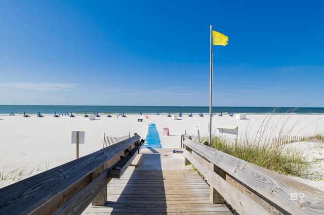 dock area featuring a water view and a beach view